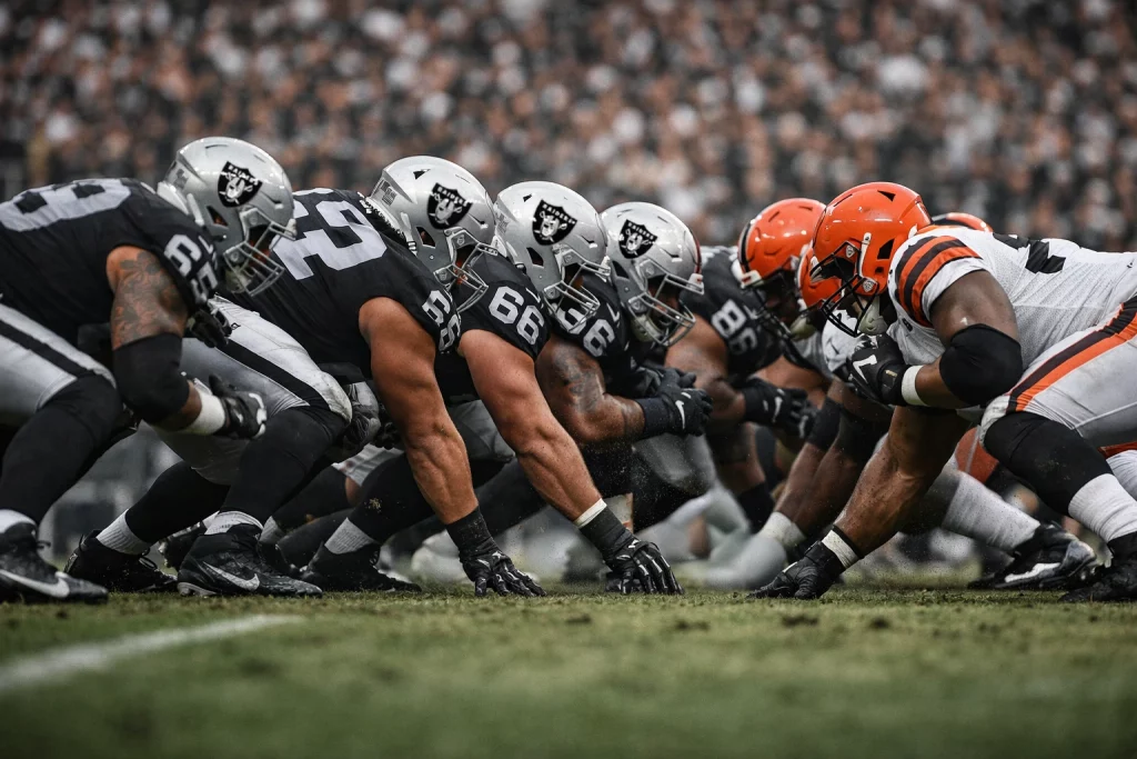 Las Vegas Raiders offensive line battling in the trenches during an NFL game, symbolizing a foundation-first draft strategy.